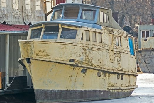 old boat standing at the dock of the frozen bay 