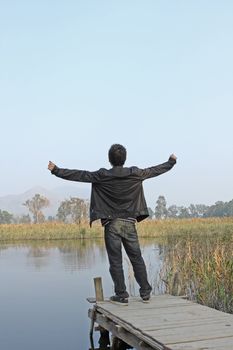 Man resting on a pontoon by a lake 