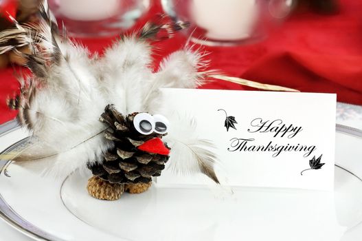 Cute little turkey sits by a place card  on a holiday table for Thanksgiving Day.