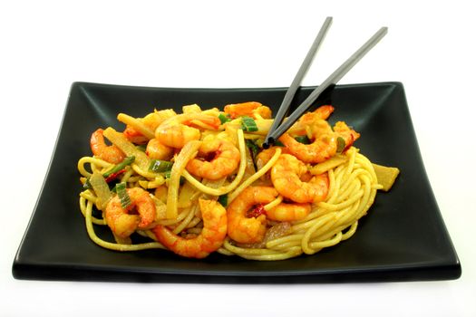 Asian noodles with shrimp and vegetable stir-fry on Asian dishes