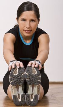 Girl doing stretching movements in a gym.