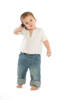 A little boy holding a cellphone near his ear