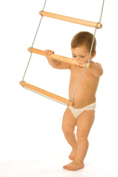 A little boy trying to climb a rope-ladder