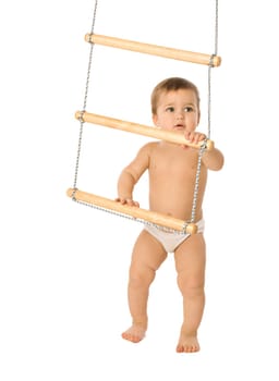 A little boy trying to climb a rope-ladder
