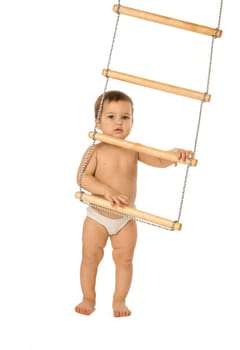 A little boy trying to climb a rope-ladder