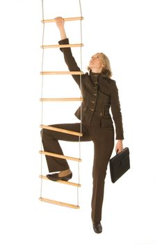 An isolated photo of a businesswoman climbing a rope-ladder