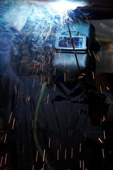 a welder working at shipyard under vessel