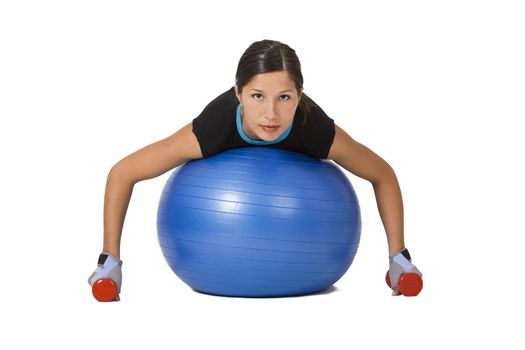 Young woman doing an exercise with barbells and a fitness ball 
