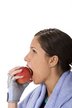 Profile of a young woman bitting a red apple.