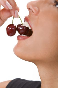 Close-up of a woman mouth bitting into a cherry.