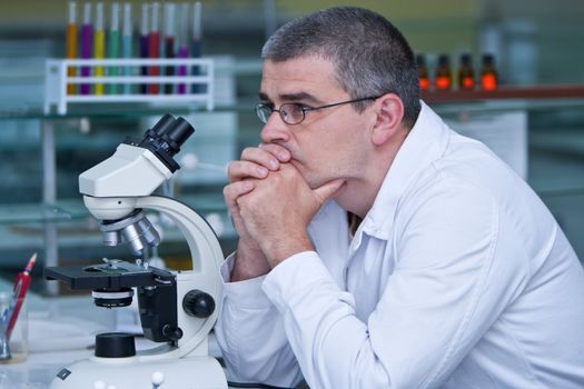 Reasearcher thinking at his workplace in a laboratory.Shot with Canon 70-200mm f/2.8L IS USM