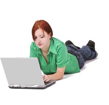 Portrait of a redheaded teenage girl lying down in front of a laptop.