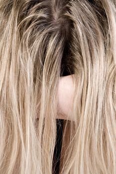 Studio portrait of a beautyfull blond model hiding behind her hair