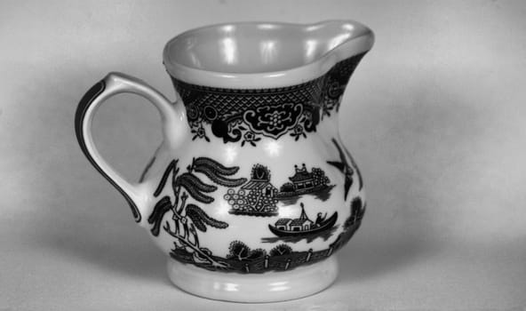 Fine china milk server in a blue willow pattern. Seen here in black and white