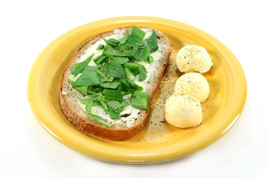a slice of buttered bread with freshly chopped wild garlic