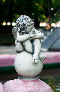 An angel statue sitting on a fountain