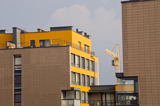 Modern houses and crane between it. Construction industry.