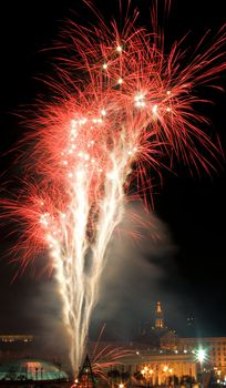 Celebratory fireworks in the night sky above the roofs