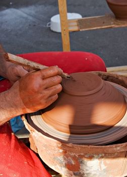 potter's wheel and hands of craftsman hold a jug 