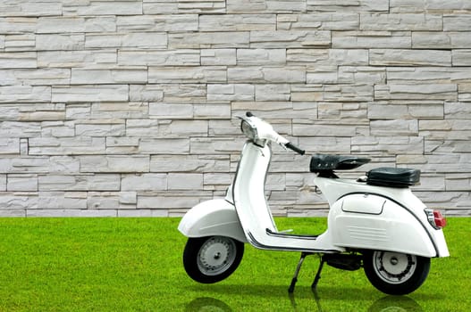 Vintage motorbike in the garden with nice stone wall background