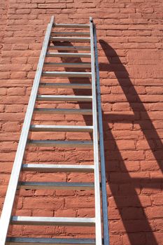 Metal ladder against red brick wall