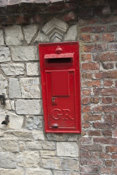 A Red British Post Box set in a stone wall