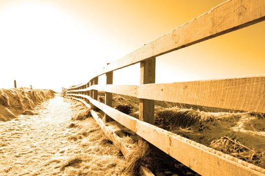 frosty winters view at ballybunion cliffside walk with bright sunset and fence