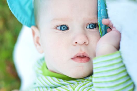 baby boy with blue eyes. outdoor shot.