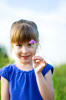 little girl with flower. outdoor shot. focus on a flower