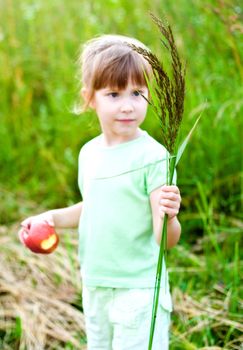 girl with bent-grass bouquet in summer meadow. focus on bouquet.