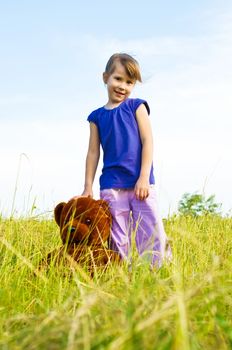 girl with teddy bear in a meadow. best friends.