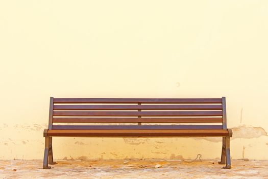 Wooden bench in front of the wall