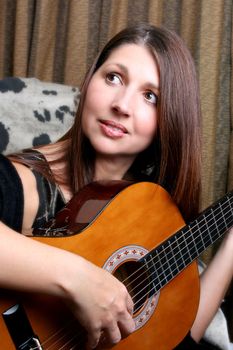 Relaxed mature model, playing guitar at home