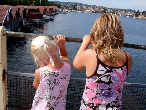 two girls looking over the sea, Kristiansand, Norway. Please note: No negative use allowed.