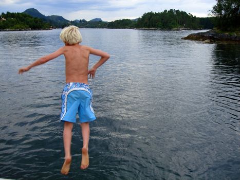 boy jumping into the sea by bergen, norway. Please note: No negative use allowed.