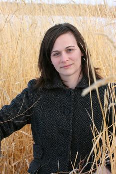 Beautiful brunette female amongst long wild grass