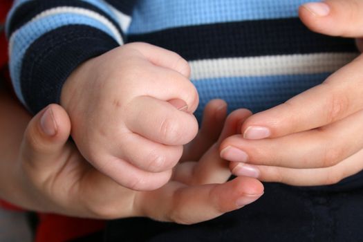 Young boy holding his baby brothers hands