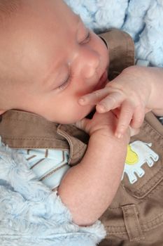 Beautiful newborn baby boy sleeping on a soft blanket