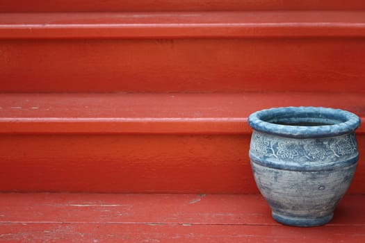 Blue ceramic pot on a red staircase