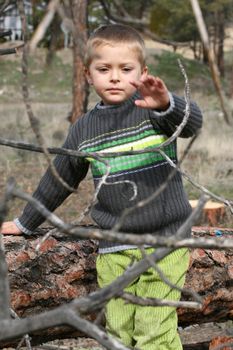 Little blond boy playing outside in the field