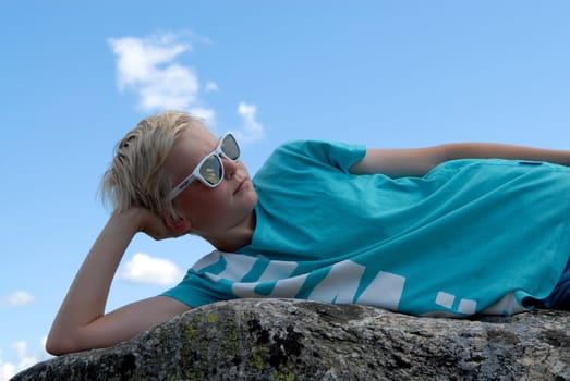 boy lying on a stone. Please note: No negative use allowed.