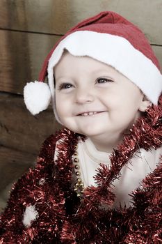 Christmas baby playing with decorations wearing a hat