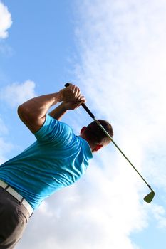 Young golfer hitting a shot with an iron