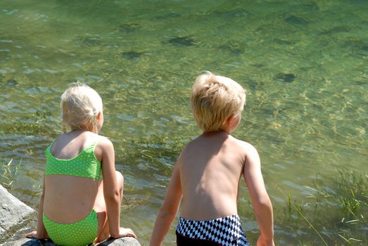 children playing by the side of water. Please note: No negative use allowed.