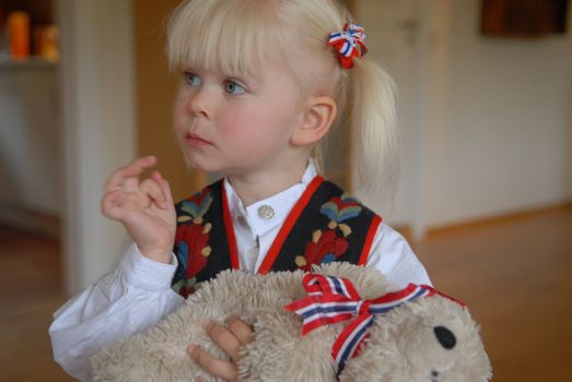 little girl holding a toy bear. Please note: No negative use allowed.