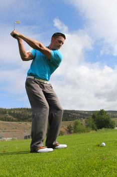 Young golfer hitting a fairway shot with an iron