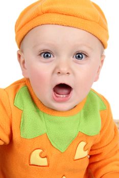 Baby dressed in a pumpkin costume on white background