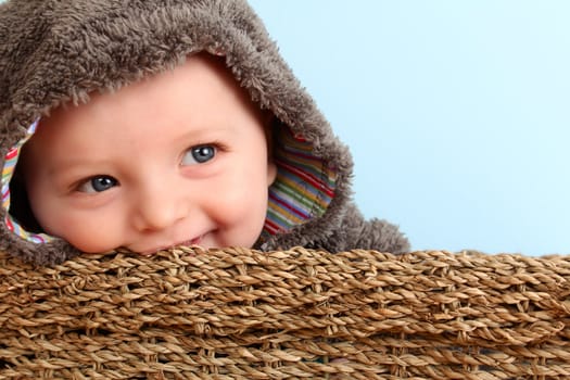 Cute baby boy wearing a fluffy suit in basket