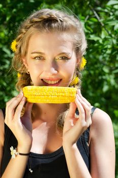 Close-up outdoor portrait of young beauty woman eating corn-cob