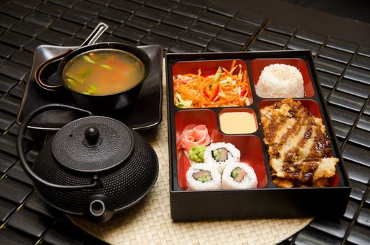 Sushi lunch with soup salad tea and sauce
